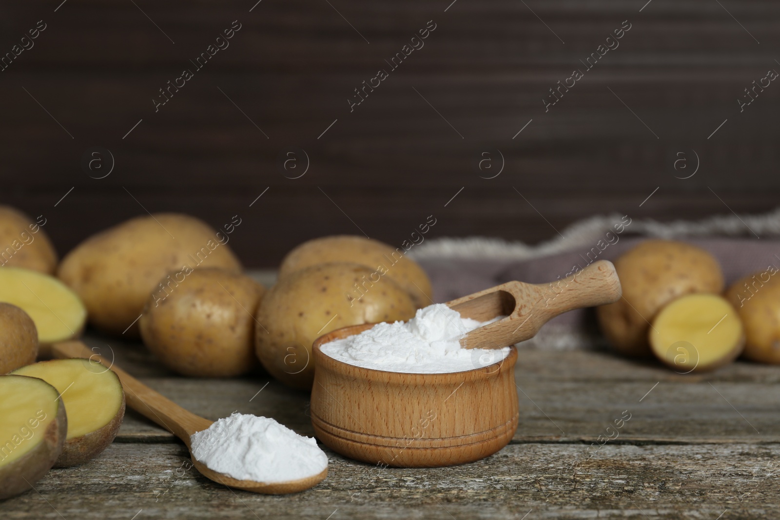 Photo of Starch and fresh raw potatoes on wooden table. Space for text