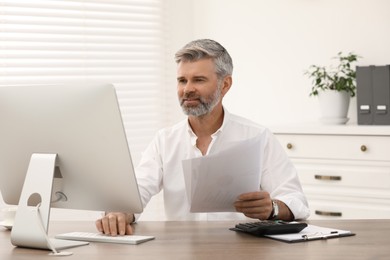 Photo of Professional accountant working at wooden desk in office