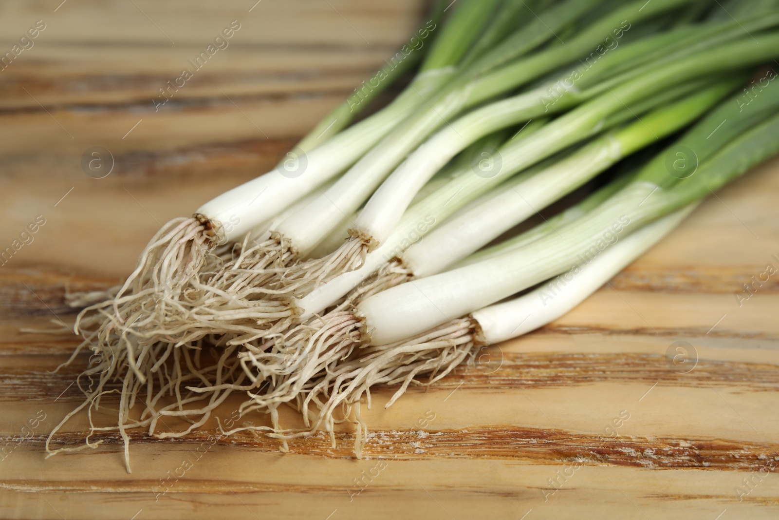 Photo of Fresh green onion on wooden table, closeup