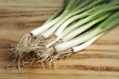 Photo of Fresh green onion on wooden table, closeup