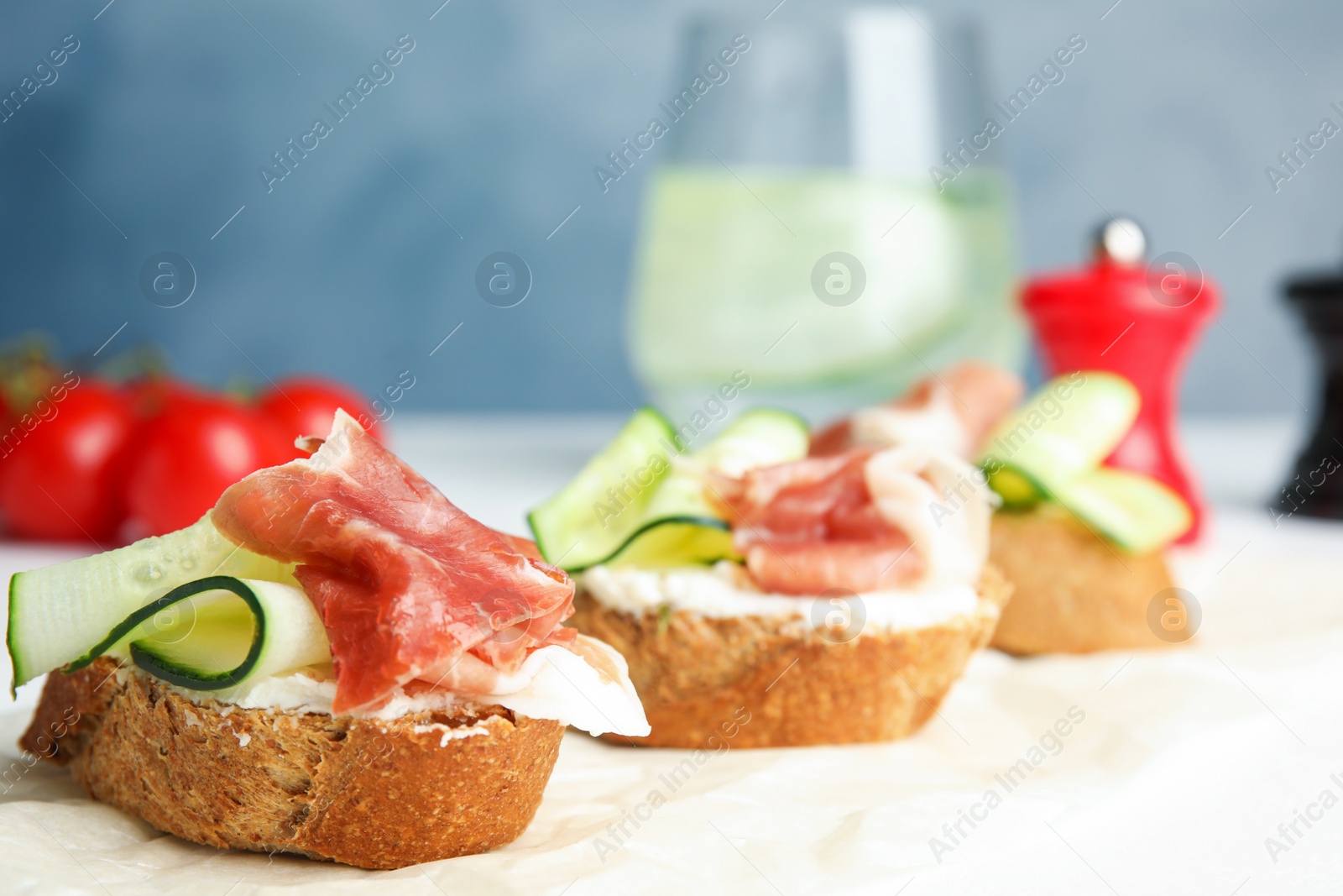 Photo of Tasty bruschettas with prosciutto served on table