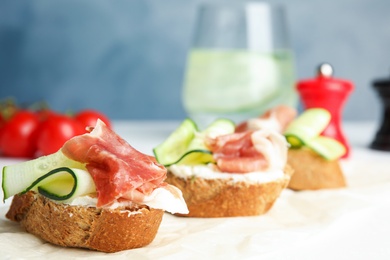 Tasty bruschettas with prosciutto served on table