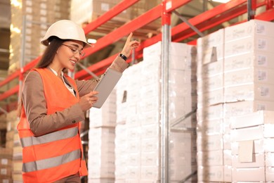 Image of Woman with tablet working at warehouse. Logistics center