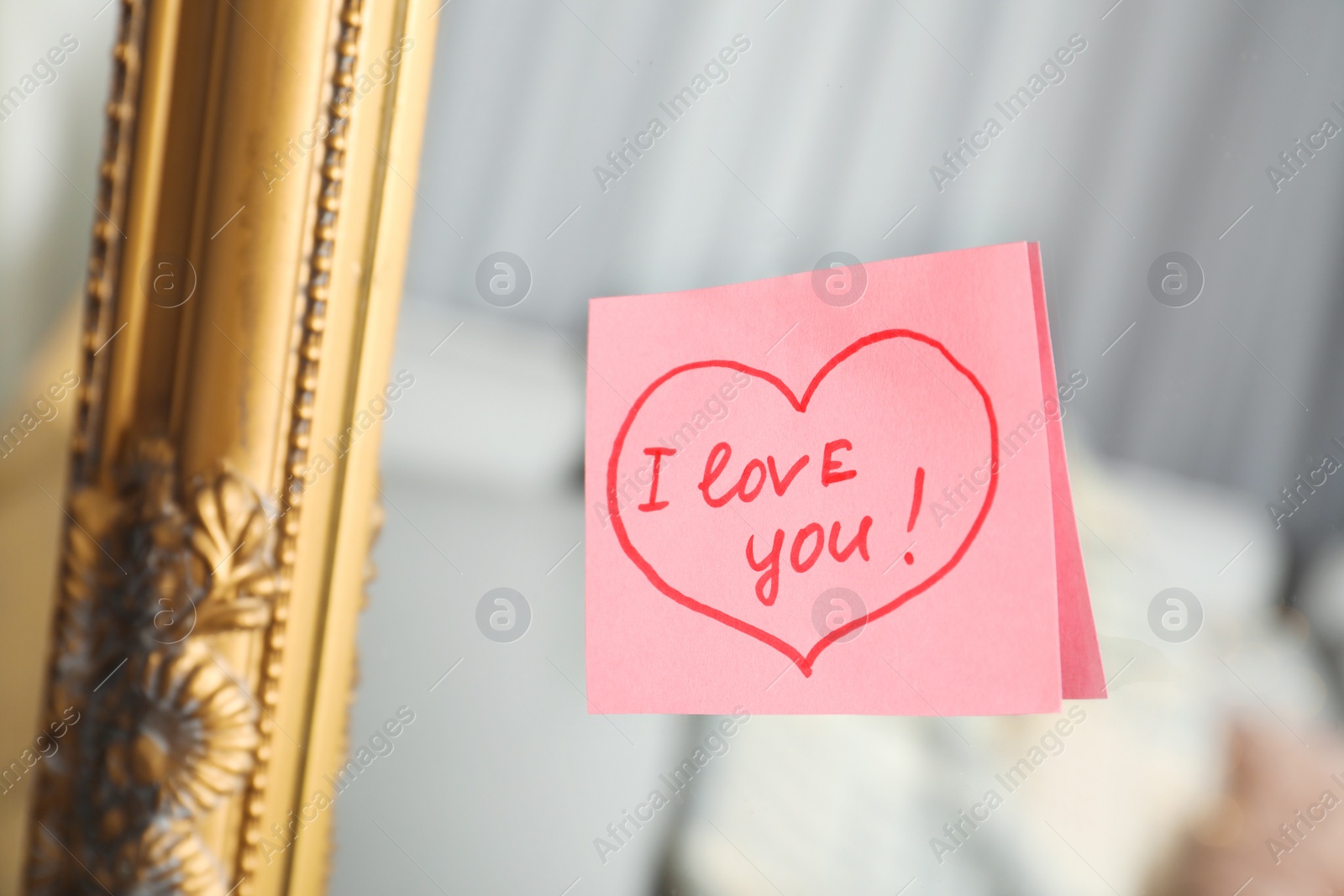 Photo of Note with phrase I Love You attached to mirror