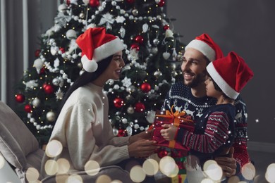 Father with his cute son presenting gift to mother at home. Christmas celebration