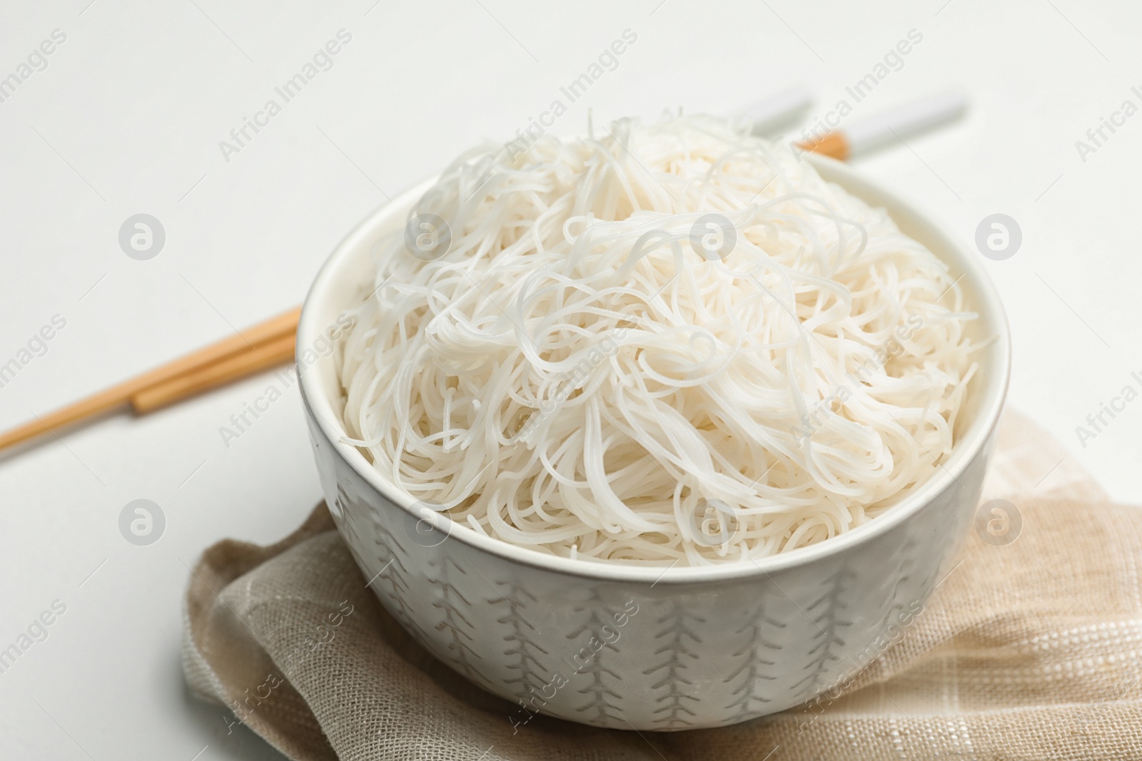 Photo of Tasty cooked rice noodles on white table, closeup