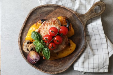 Photo of Serving board with tasty grilled meat and vegetables on light table, top view