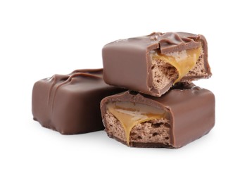 Pieces of chocolate bars with caramel on white background