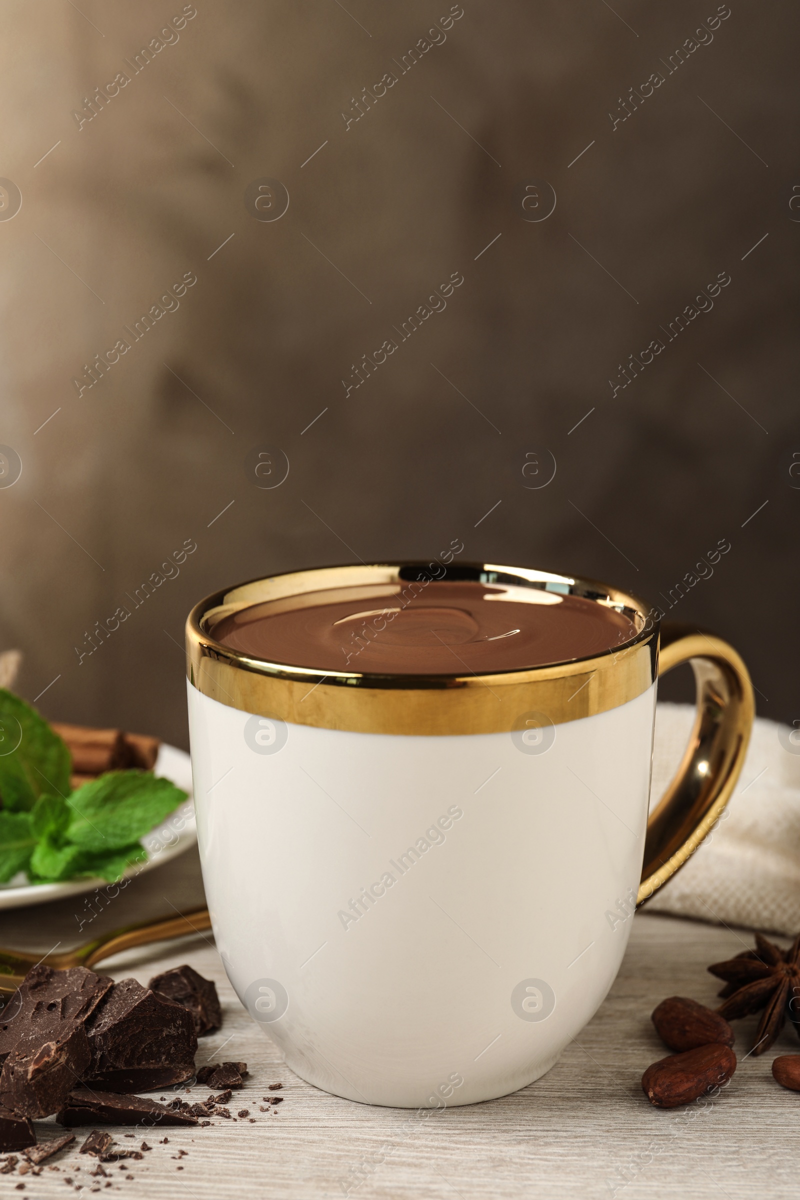 Photo of Yummy hot chocolate in cup on white wooden table