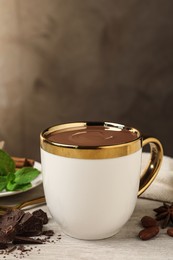 Photo of Yummy hot chocolate in cup on white wooden table