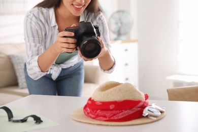 Young photographer taking picture of accessories indoors, closeup