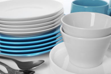 Set of clean tableware on white background, closeup. Washing dishes