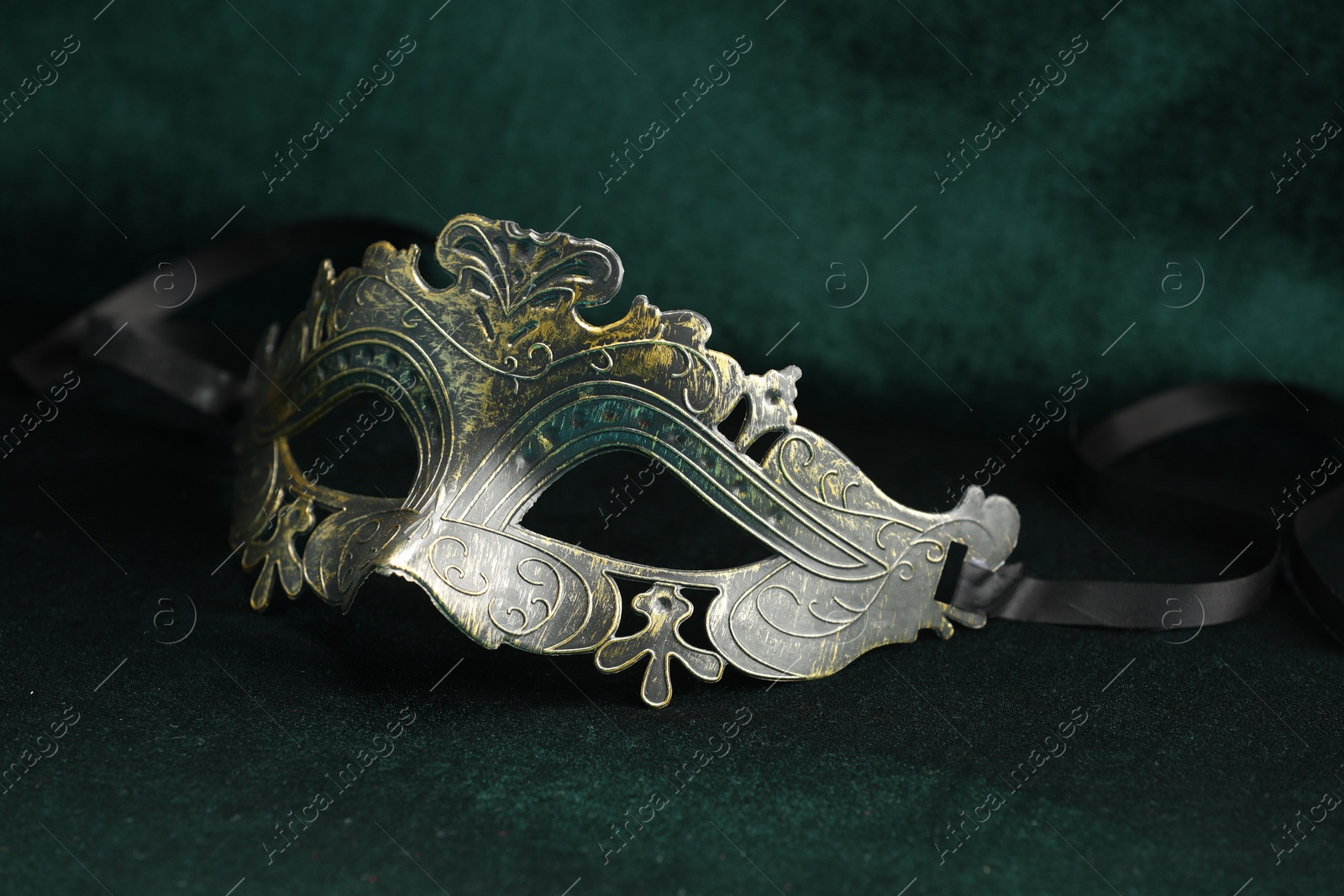 Photo of Theater arts. Venetian carnival mask on green fabric