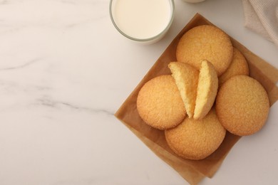 Photo of Delicious Danish butter cookies and milk on white marble table, flat lay. Space for text