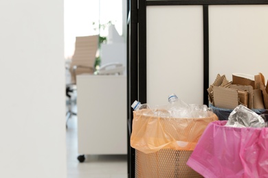 Full trash cans in modern office, space for text. Waste recycling