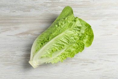 Photo of Fresh green romaine lettuce on white wooden table, top view