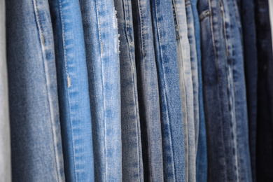 Photo of Different stylish jeans as background, closeup view