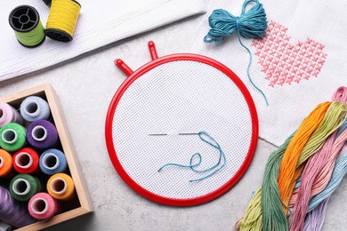 Photo of Flat lay composition with embroidery hoop on light grey background, top view