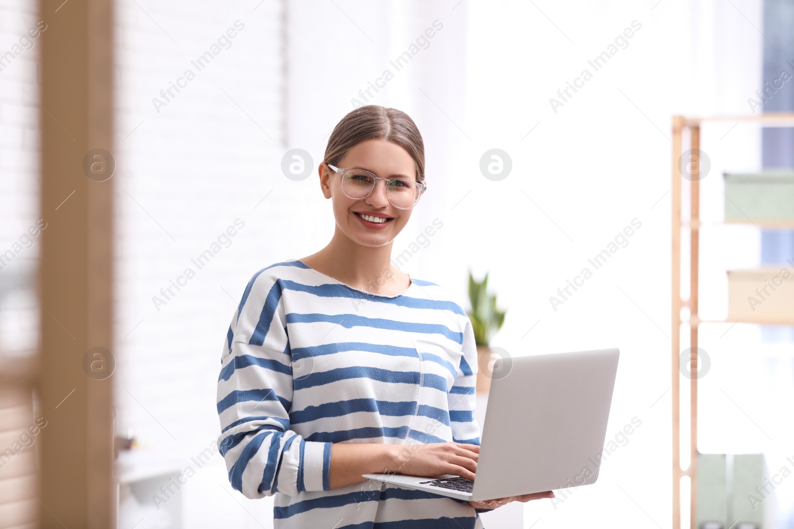 Photo of Young journalist with laptop in light office