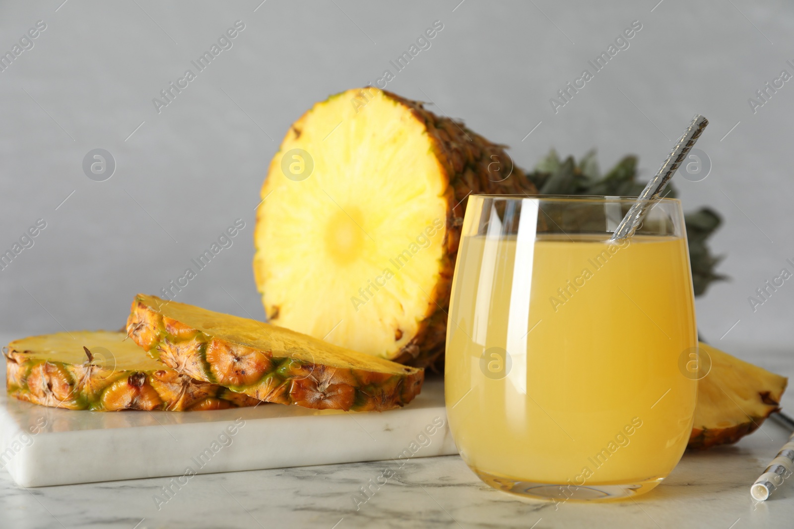 Photo of Delicious pineapple juice and fresh fruit on white marble table