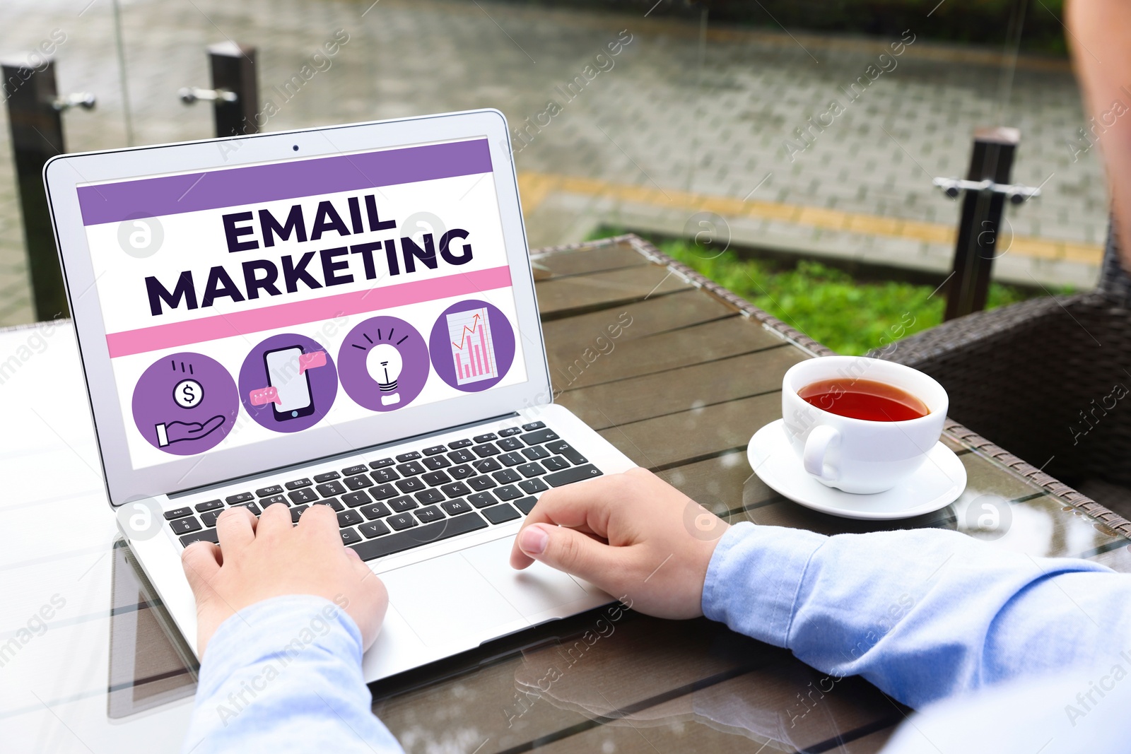 Image of Email marketing. Man using laptop at table outdoors, closeup