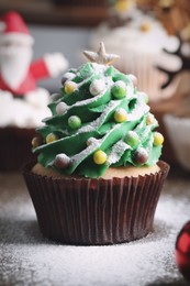 Photo of Christmas tree shaped cupcake on table, closeup