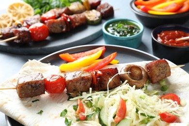 Photo of Delicious shish kebabs with vegetables served on table, closeup