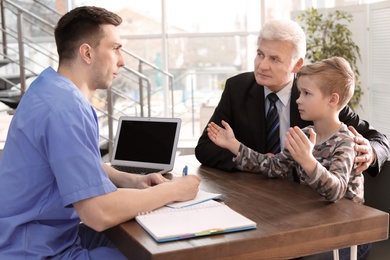 Photo of Senior man with his grandson having appointment at child psychologist office