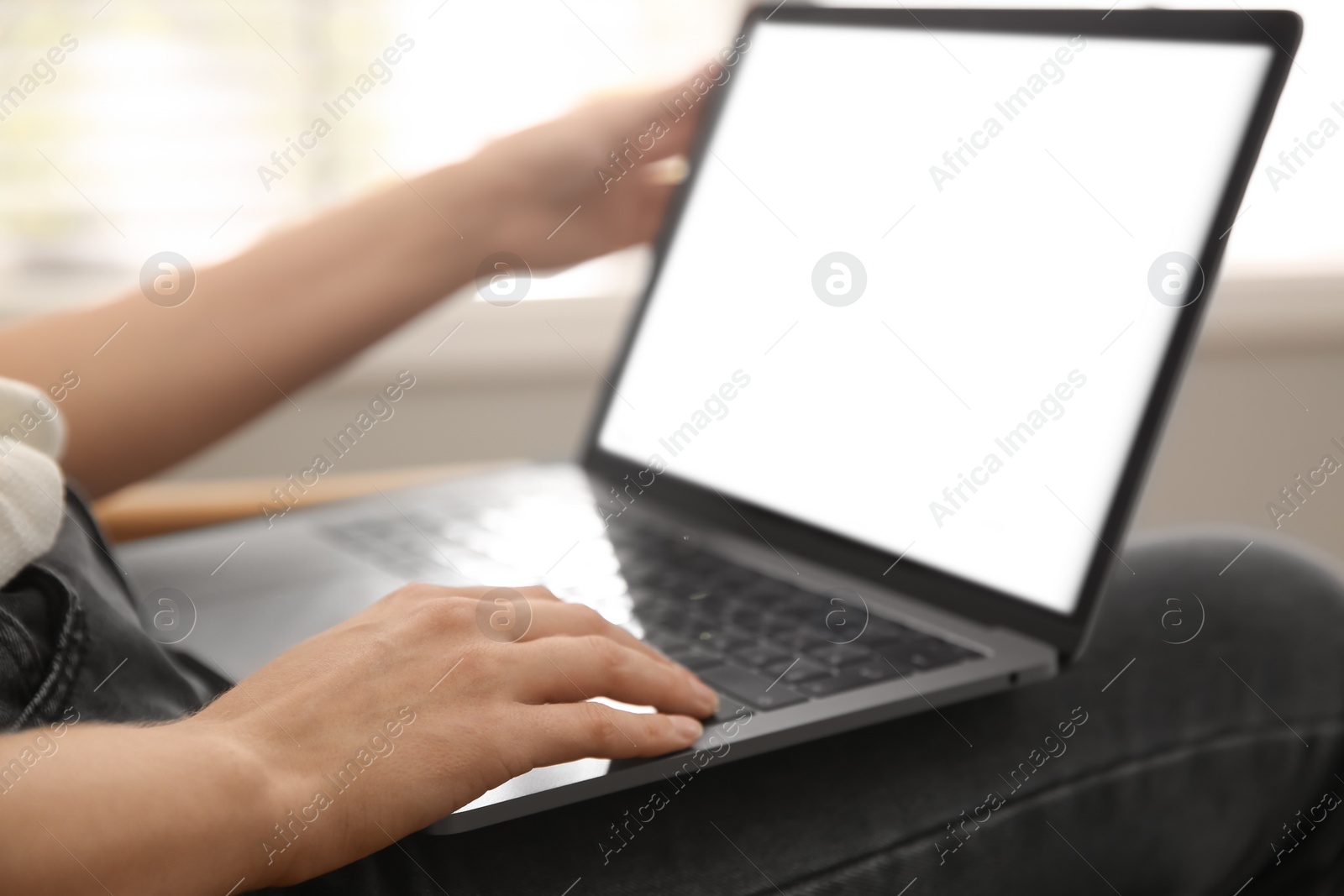 Photo of Woman working with modern laptop indoors, closeup