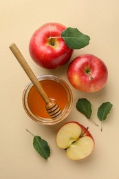 Delicious apples, jar of honey, leaves and dipper on beige background, flat lay