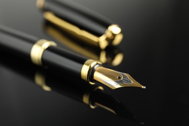 Photo of Beautiful fountain pen with ornate nib on black background, closeup