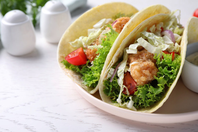 Photo of Yummy fish tacos served on white wooden table, closeup