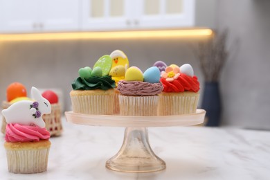 Tasty decorated Easter cupcakes on white marble table