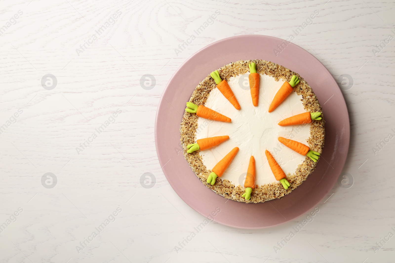 Photo of Dish with tasty carrot cake on white wooden table, top view. Space for text