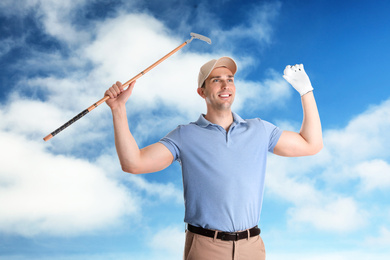 Image of Young man with golf club against blue sky