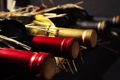 Bottles with delicious wine on shelf, closeup. Professional sommelier