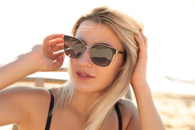 Photo of Beautiful woman wearing sunglasses outdoors on sunny day