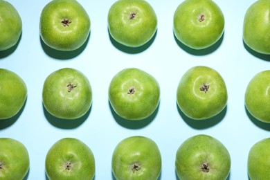 Photo of Ripe green apples on light blue background, flat lay