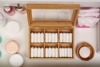 Photo of Storage of tampons and different hygiene products in white drawer, flat lay