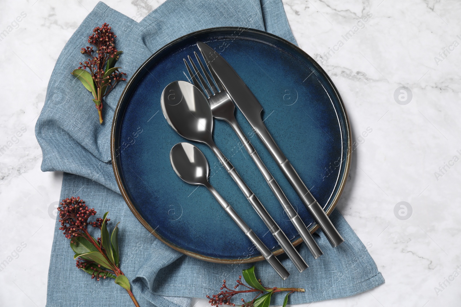 Photo of Stylish setting with elegant cutlery on white marble table, top view