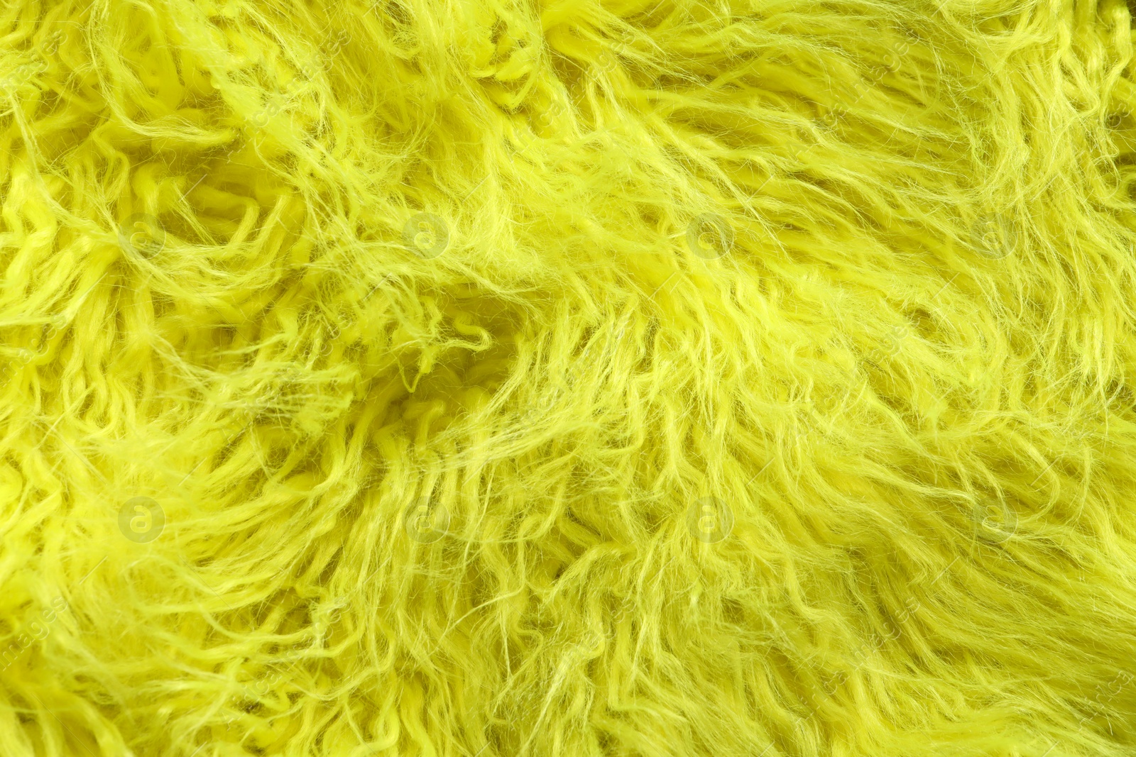 Photo of Texture of yellow faux fur as background, closeup