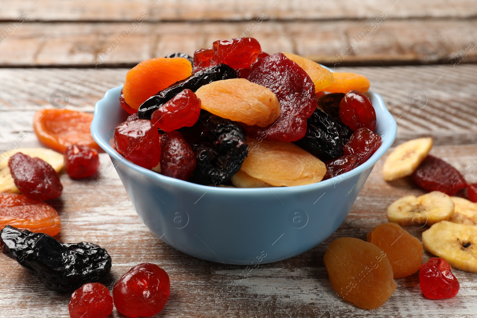 Photo of Mix of delicious dried fruits on wooden table, closeup