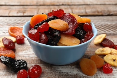 Photo of Mix of delicious dried fruits on wooden table, closeup