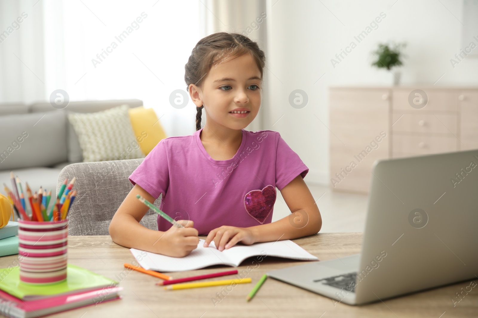 Photo of Distance learning, studying at home. Girl having online school lesson during quarantine and lockdown due to Covid-19 pandemic