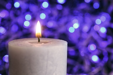 Burning wax candle on blurred background, closeup