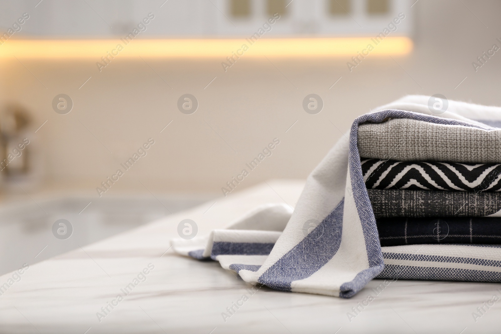 Photo of Many soft kitchen towels on white marble table indoors, space for text