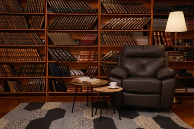 Photo of Cozy home library interior with leather armchair and collection of vintage books on shelves
