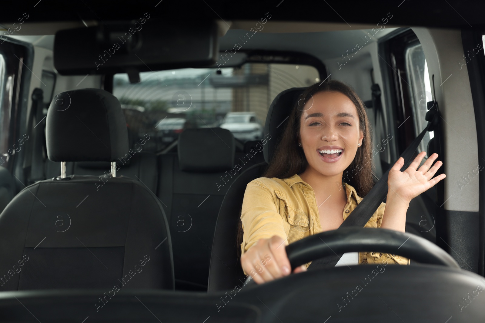 Photo of Listening to radio. Beautiful woman enjoying music in car, view through windshield