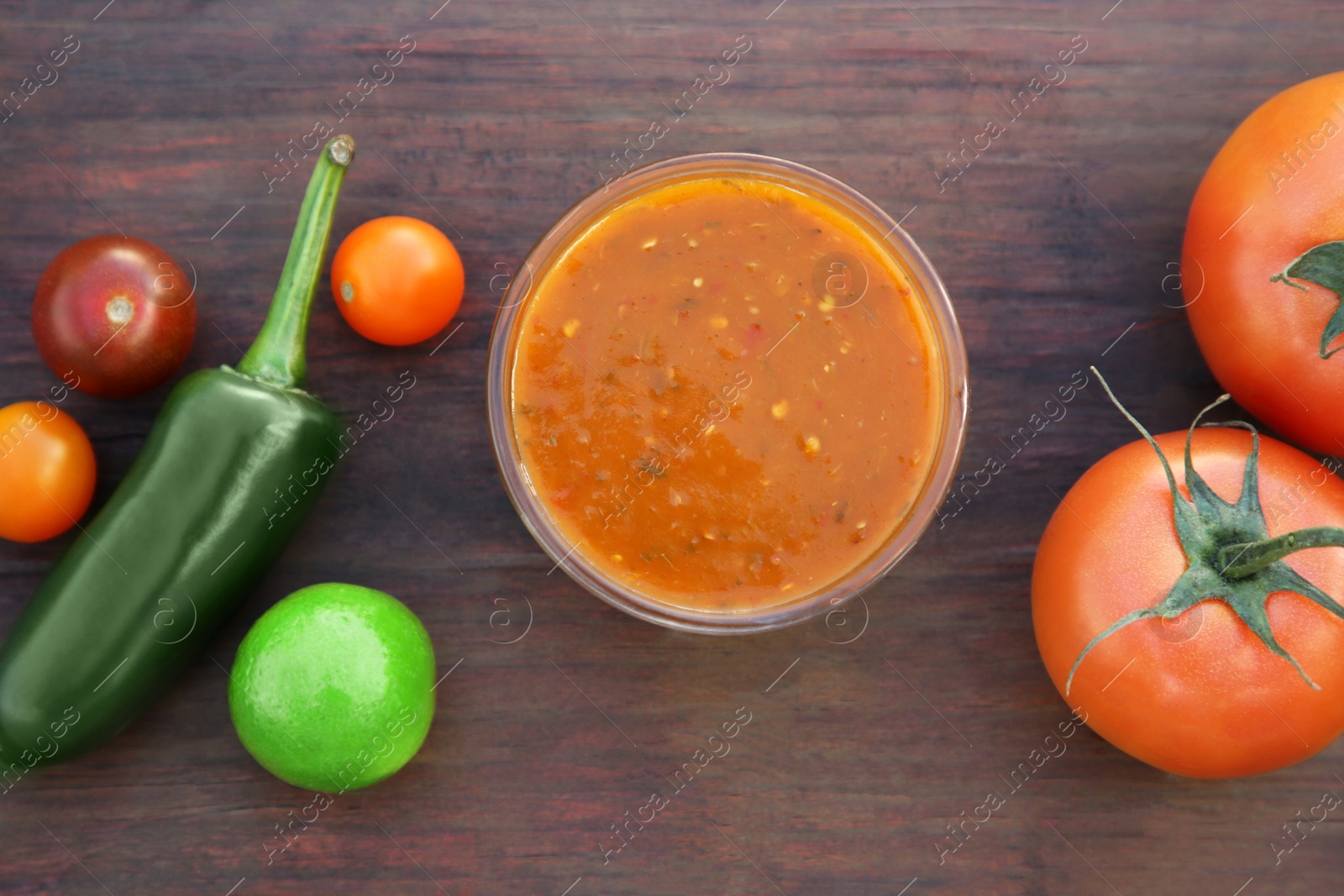 Photo of Tasty salsa sauce and ingredients on wooden table, flat lay