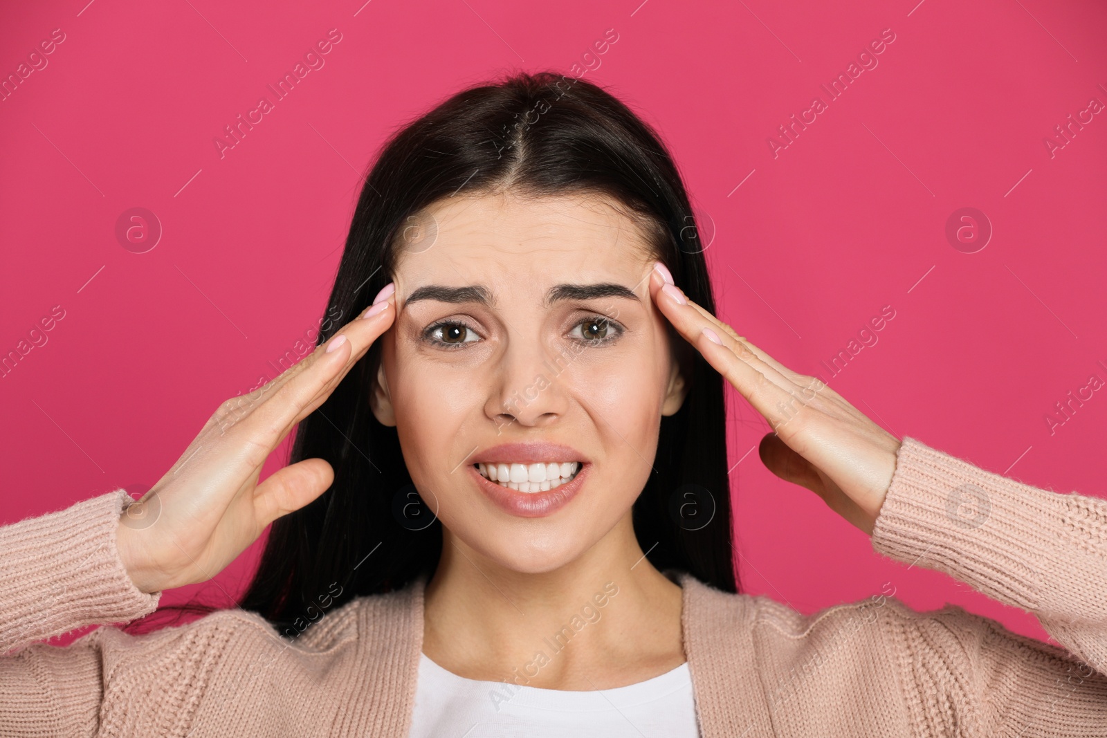 Photo of Woman suffering from migraine on pink background